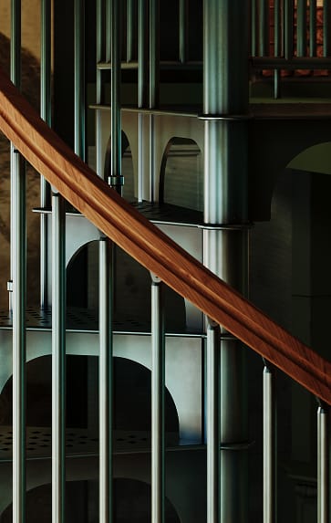 American Industrial spiral staircase wood handrail curving alongside the continuous collars