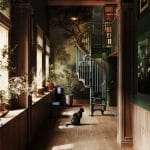 American Industrial spiral staircase framed by an archway leading into a home library hallway