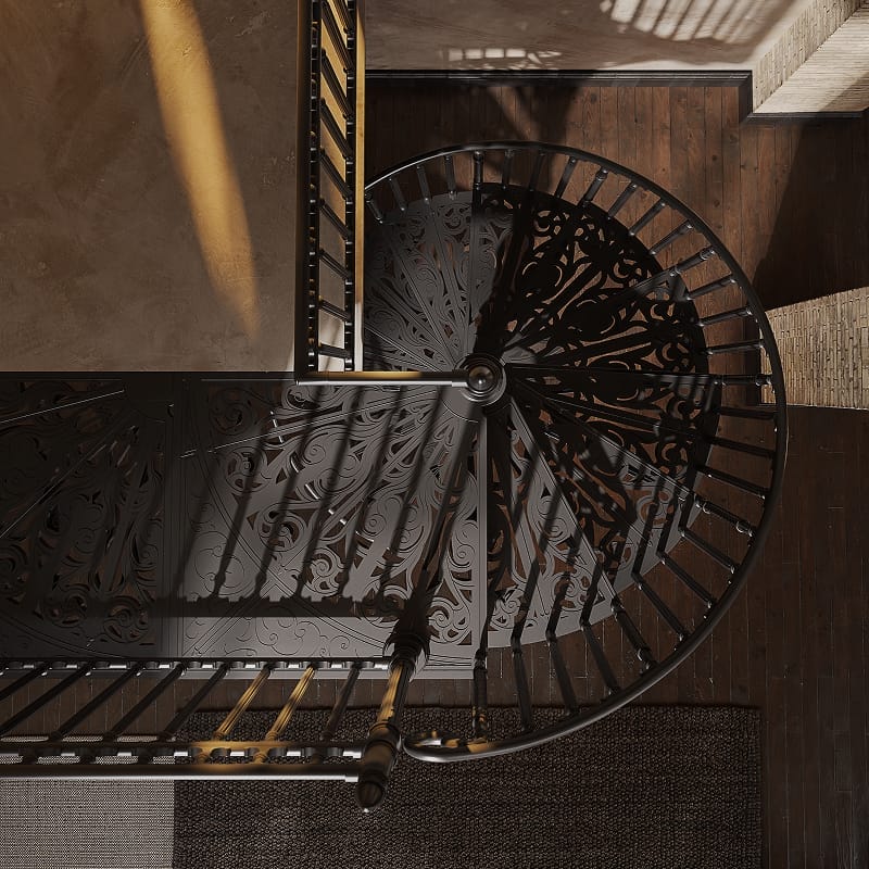 Overhead view of a Victorian spiral staircase showing ornate scrollwork in the treads and railing