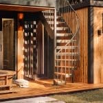 Outdoor combination staircase leading up the exterior of a modern wood-paneled cabin