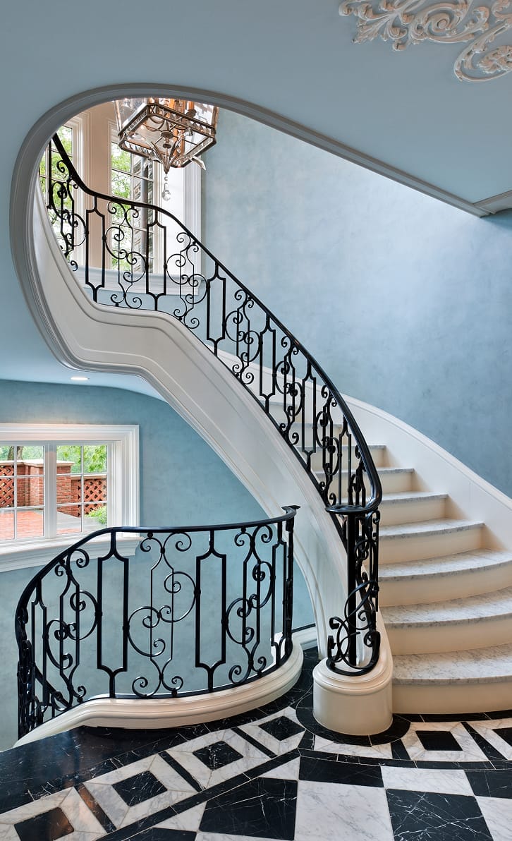 Twisting, cantilevered stair with detailed ironwork within the guardrail