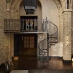 Victorian spiral staircase with a balcony landing in a vaulted interior